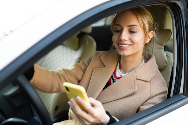 mooie jonge vrouw autorijden met een telefoon