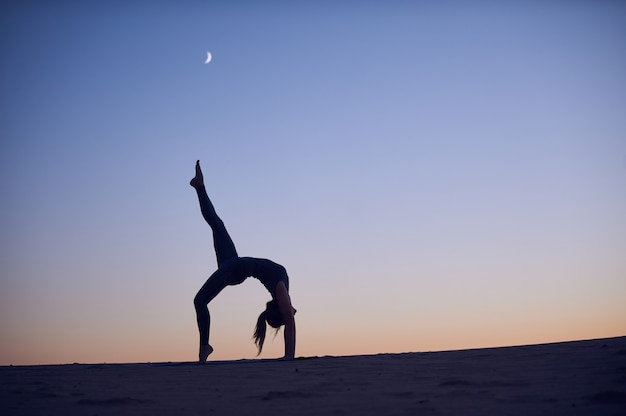 Mooie jonge vrouw beoefent backbend yoga asana Eka Pada Urdhva Dhanurasana