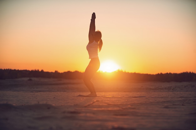 Mooie jonge vrouw beoefent yoga asana Utkatasana