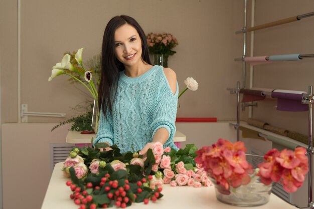 mooie jonge vrouw bereidt boeketten bloemen