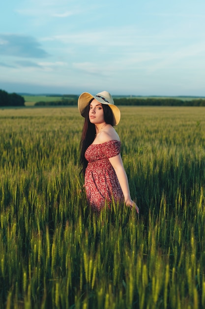 Mooie jonge vrouw bij zonsondergang in het veld