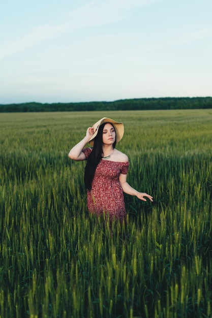 Mooie jonge vrouw bij zonsondergang in het veld