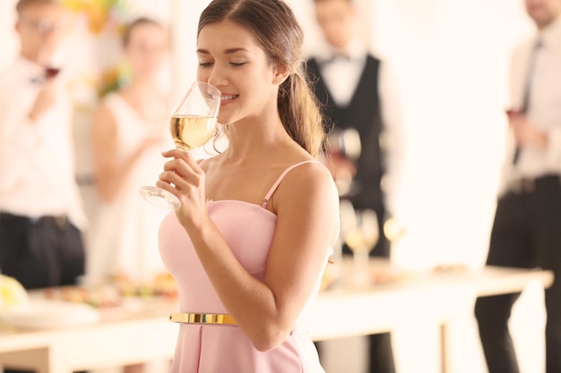 Mooie jonge vrouw champagne drinken op feestje