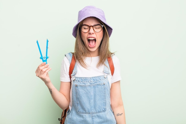 mooie jonge vrouw die agressief schreeuwt en er erg boos uitziet. studentenconcept