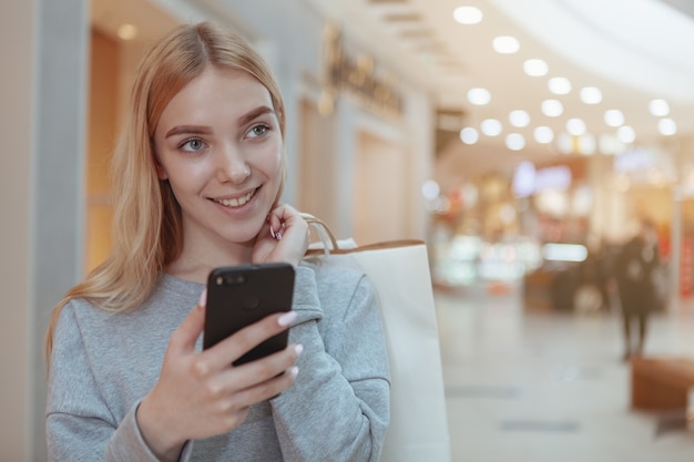 Mooie jonge vrouw die bij het lokale wandelgalerij winkelt