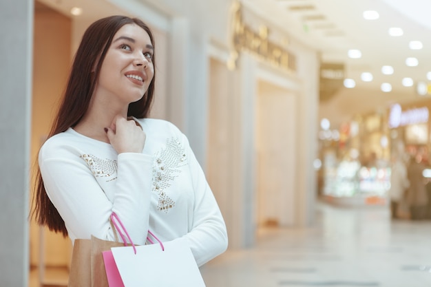 Mooie jonge vrouw die bij het lokale wandelgalerij winkelt