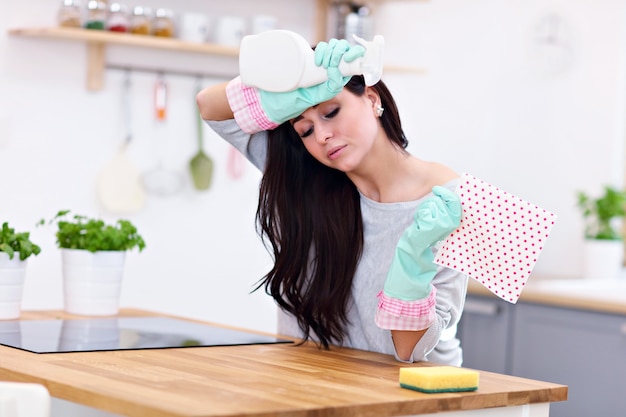 mooie jonge vrouw die de keuken schoonmaakt