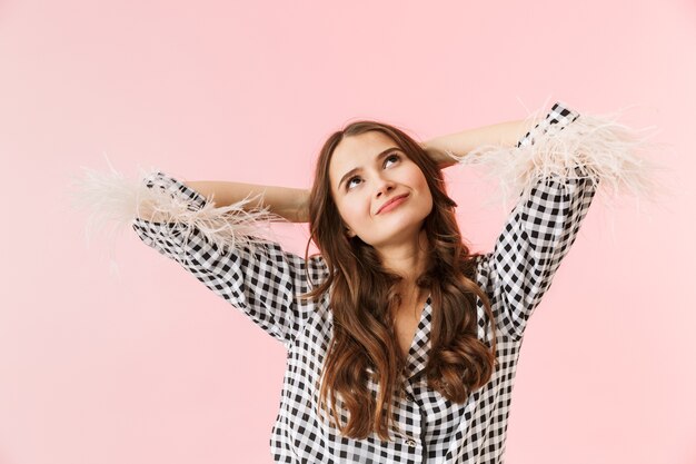 Mooie jonge vrouw die een jasje draagt dat zich geïsoleerd over roze achtergrond bevindt, die zich voordeed