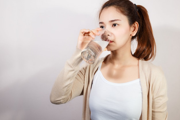 Mooie jonge vrouw die een vers glas water drinkt