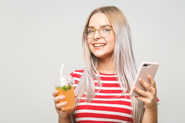 Mooie jonge vrouw die een zelfgemaakt detoxsap drinkt