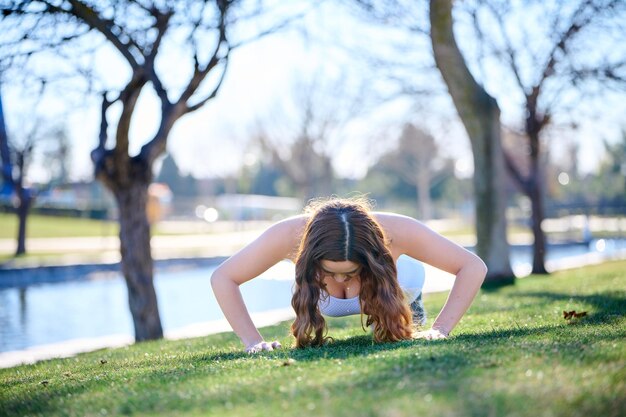 Foto mooie jonge vrouw die in een park uitoefent