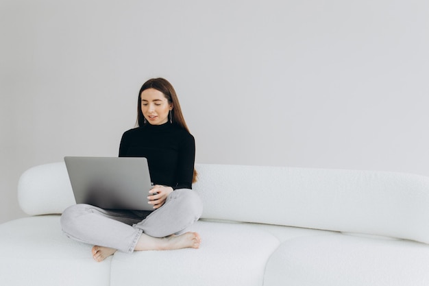 Mooie jonge vrouw die laptop thuis met behulp van