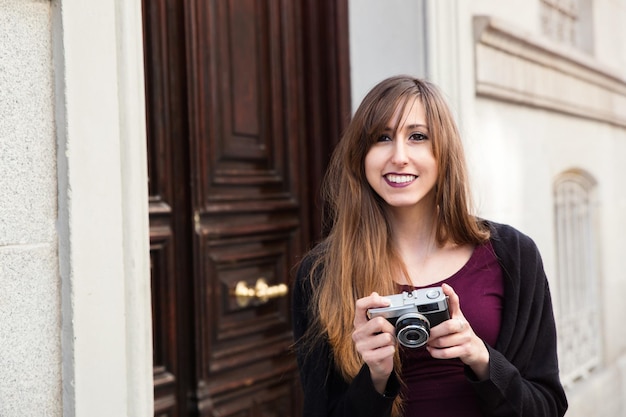 Mooie jonge vrouw die met de camera staat