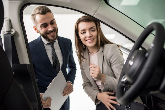 Mooie jonge vrouw die nieuwe auto kiest