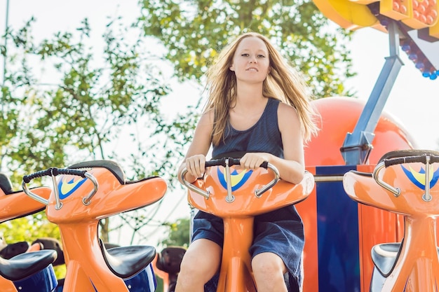 Mooie, jonge vrouw die plezier heeft in een pretpark