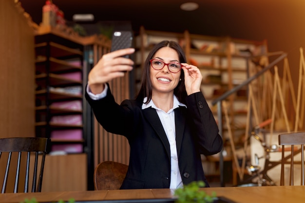 Mooie jonge vrouw die selfie bij cafetaria.