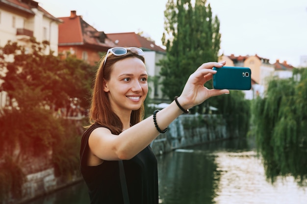 Mooie jonge vrouw die selfie foto maakt op mobiele telefoon in het oude centrum van Ljubljana Slovenië