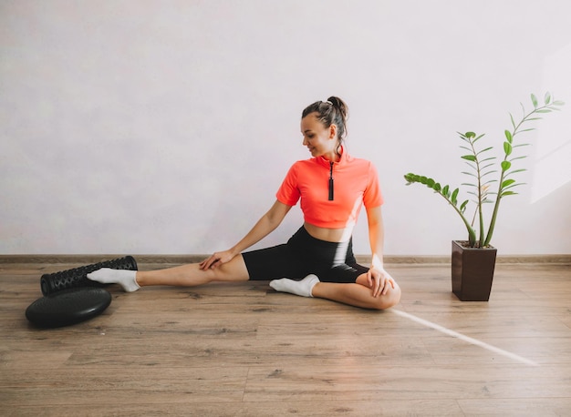 Mooie jonge vrouw die thuis fitness en yoga doet