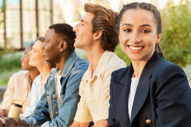 Mooie jonge vrouw die tijd doorbrengt met haar vrienden multiculturele studenten