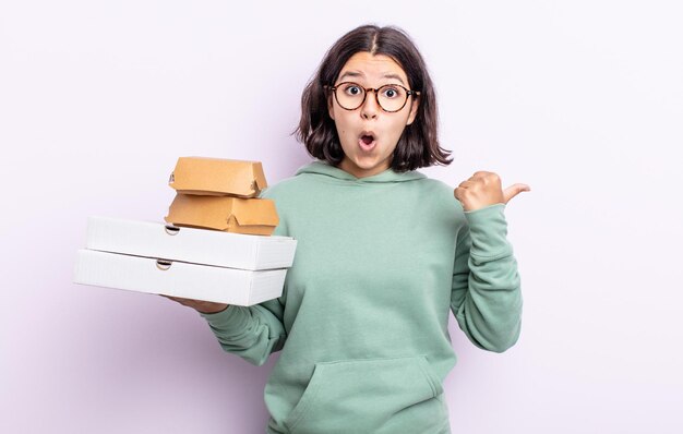 mooie jonge vrouw die verbaasd in ongeloof kijkt. fastfood afhaalconcept