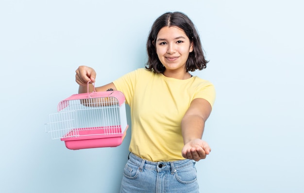 Mooie jonge vrouw die vrolijk lacht met vriendelijk en een concept aanbiedt en toont. huisdier kooi concept