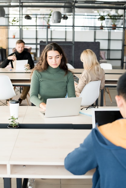 Mooie jonge vrouw die werkt in Open Office