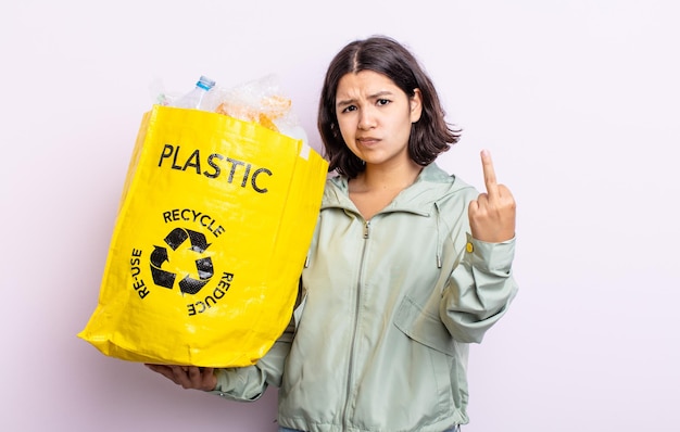 Mooie jonge vrouw die zich boos, geïrriteerd, opstandig en agressief voelt. kunststof recyclingconcept