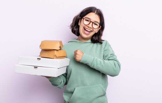 Mooie jonge vrouw die zich gelukkig voelt en een uitdaging aangaat of viert. fastfood afhaalconcept