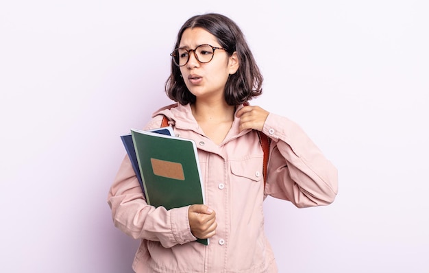 Mooie jonge vrouw die zich gestrest, angstig, moe en gefrustreerd voelt. student met boeken concept