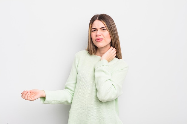 mooie jonge vrouw die zich gestrest, gefrustreerd en moe voelt, over pijnlijke nek wrijft, met een bezorgde, verontruste blik