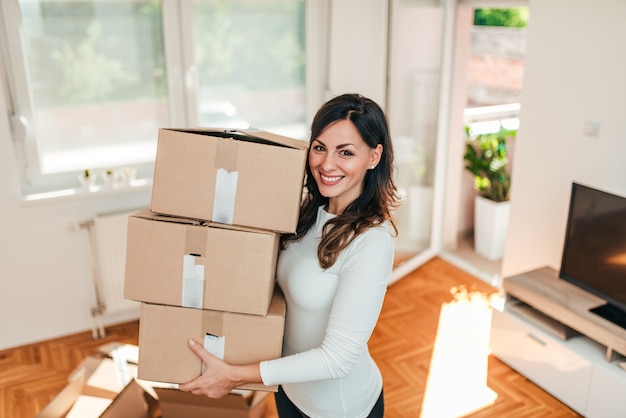 Mooie jonge vrouw die zich in de nieuwe flat beweegt.