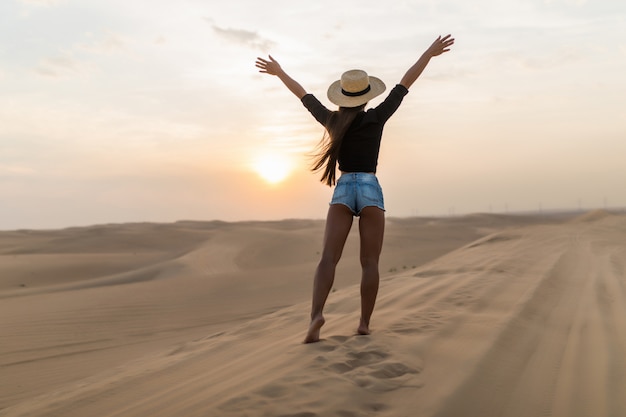 Mooie jonge vrouw die zich voordeed op het zand