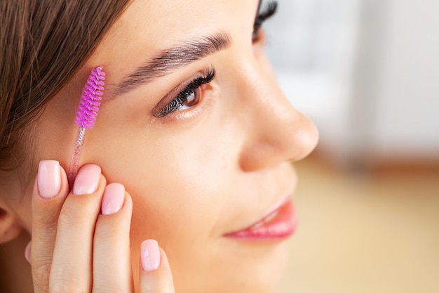 Mooie jonge vrouw doet make-up in haar badkamer