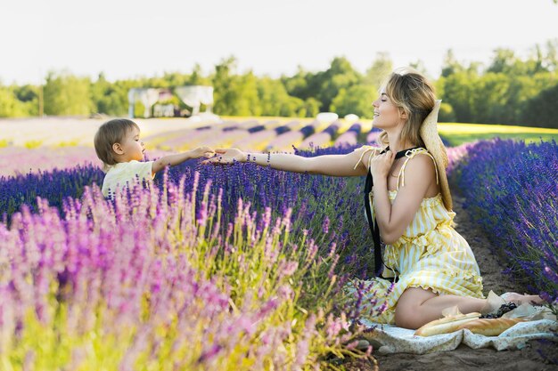 Mooie jonge vrouw en haar schattige zoontje in het lavendelveld