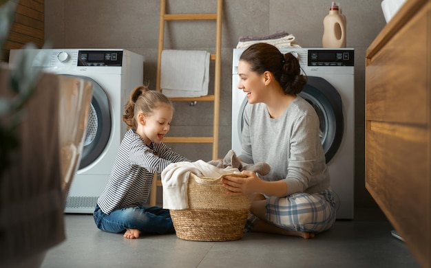 Mooie jonge vrouw en kleine helper van het kindmeisje hebben plezier en glimlachen