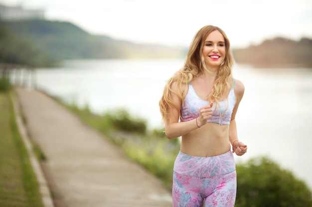 mooie jonge vrouw gaat in de zomer sporten in de natuur