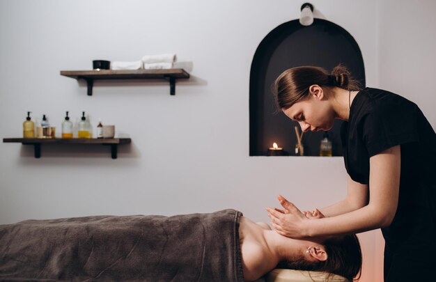 Mooie jonge vrouw genieten van massage in spa salon