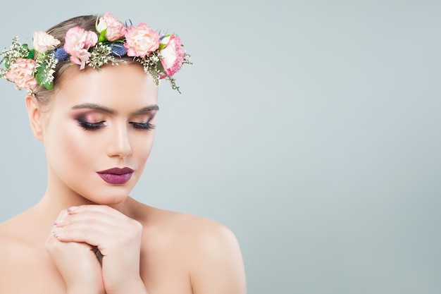 Mooie jonge vrouw gezicht close-up portret Meisje in lente bloemen krans Gezichtsbehandeling anti aging en huidverzorging