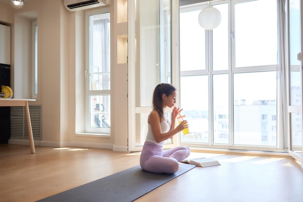 Mooie jonge vrouw het praktizeren yoga thuis