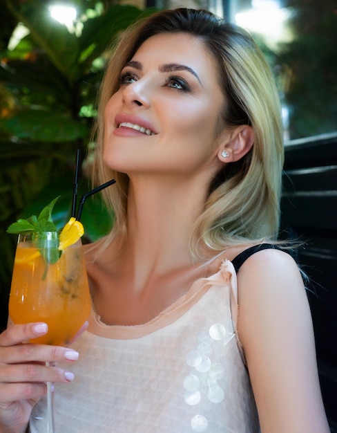 Mooie jonge vrouw in avondjurk met cocktail portret van sexy vrouw met een cocktail jong