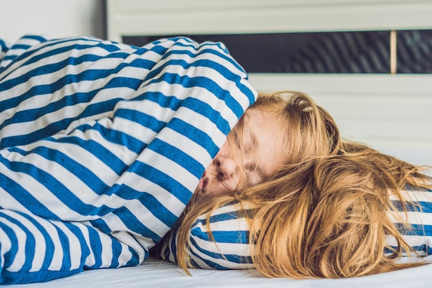 Mooie jonge vrouw in bed liggen en slapen. Krijg niet genoeg slaapconcept