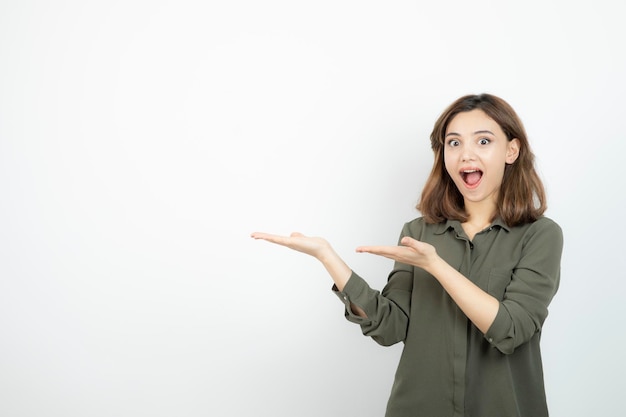 Mooie jonge vrouw in casual outfit met haar geopende handpalmen. Hoge kwaliteit foto