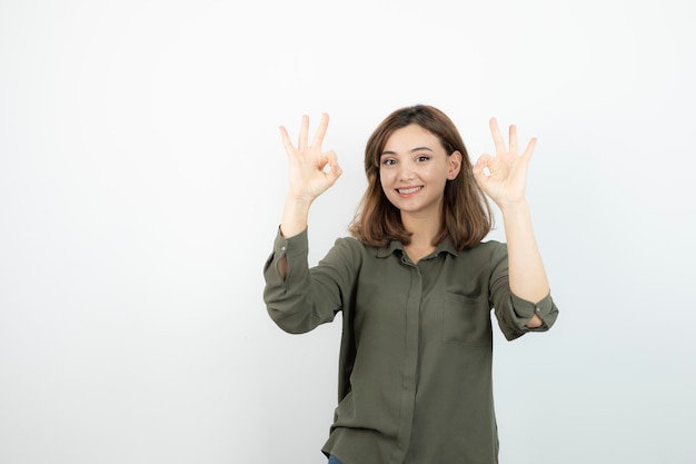 Mooie jonge vrouw in casual outfit weergegeven: ok teken. Hoge kwaliteit foto