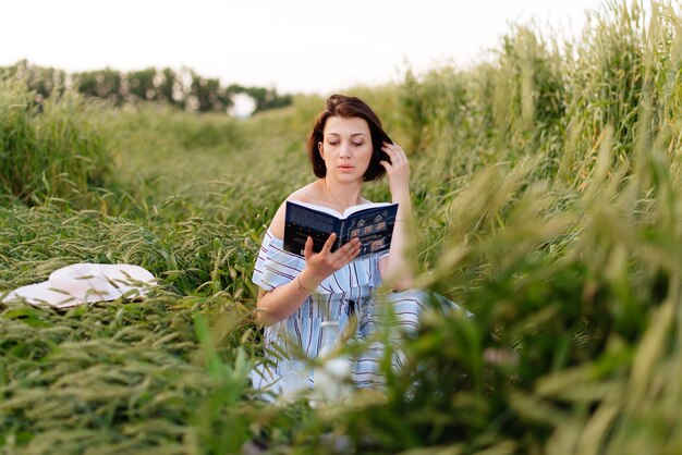 Mooie jonge vrouw in de zomer in een tarweveld