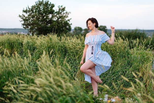 Mooie jonge vrouw in de zomer in een tarweveld