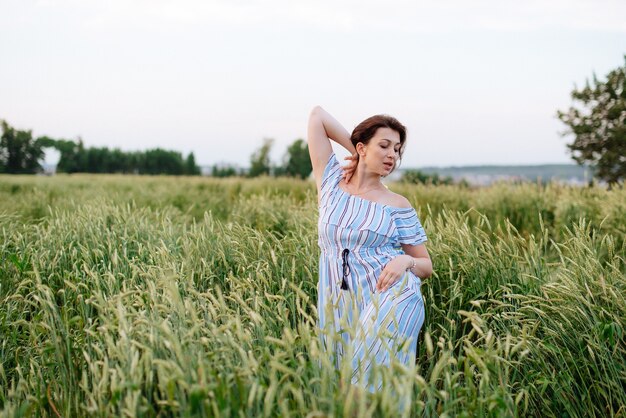 Mooie jonge vrouw in de zomer in een tarweveld