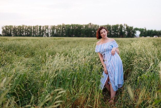 Mooie jonge vrouw in de zomer in een tarweveld