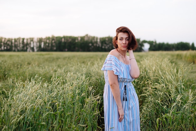 Mooie jonge vrouw in de zomer in een tarweveld