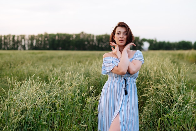 Mooie jonge vrouw in de zomer in een tarweveld