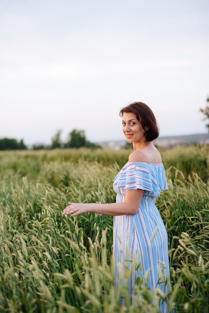 Mooie jonge vrouw in de zomer in een tarweveld